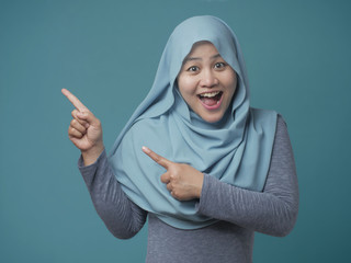 Attractive Muslim Woman Smiling and  Pointing to The Side
