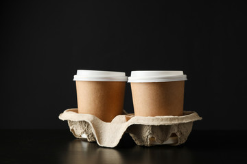 Eco - friendly coffee cups on black background, space for text