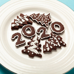 New Year and Christmas chocolate gingerbread cookies in silhouette of 2020. Homemade delicious bakery, sweet family time and traditions.