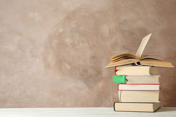 Stack of books against brown background, space for text