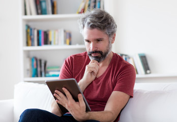 Mann mit grauen Haaren liest online Nachrichten