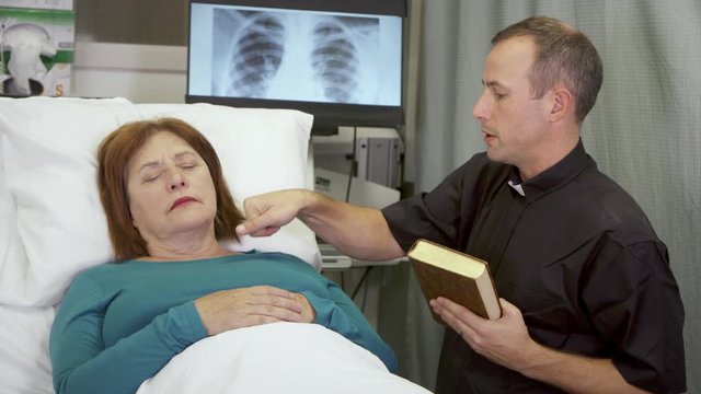 A Priest Delivers Last Rites To A Woman Who Is Near Death In The Hospital.