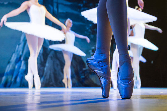 Legs of ballerinas dancing in ballet Swan Lake.