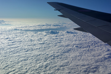 Fototapeta na wymiar Sea of clouds looking down from airplane window