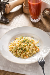 Tasty Pearl barley porridge with carrot on fabric napkin on the table
