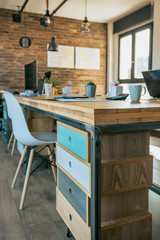 Empty industrial style office with wooden chest of drawers in the foreground