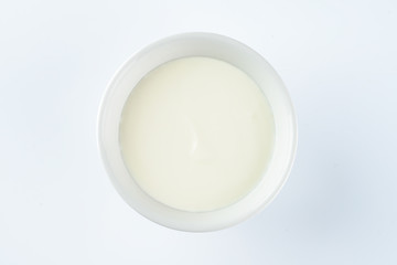 Bowl of cream on white background, top view