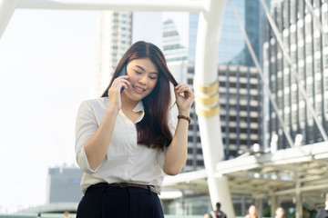Fototapeta premium Close up portrait of a professional business woman smiling calling smartphone urban city downtown