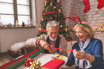 Senior couple wrapping Christmas gifts