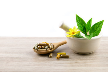 Herbal capsule from herbs nature for good health, vitamin, mineral supplement pills for medication disease on wooden medical background with copy space, medicine and drug concept