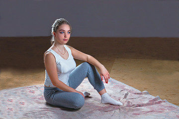 Fototapeta na wymiar Girl practices yoga indoors on a rug on the floor