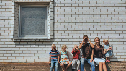 Fototapeta na wymiar A large family with four children in front of their own home.