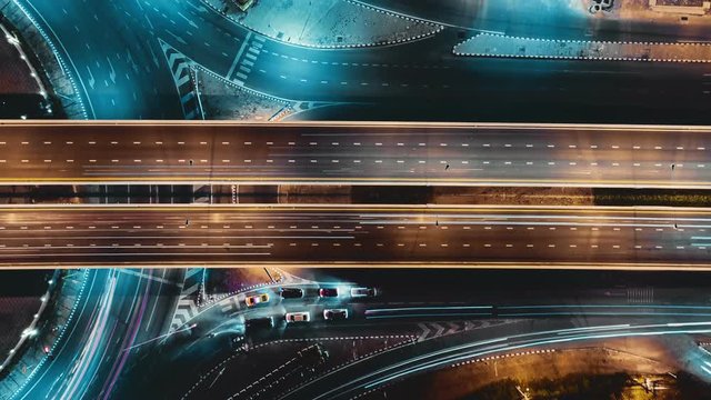 Hyperlapse timelapse of night city traffic on 4-way stop street intersection circle roundabout in bangkok, thailand. 4K UHD horizontal aerial view.