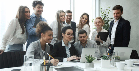 Happy business team analyzing data on laptop together