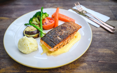 Salmon fillet with hollandaise sauce on white plate
