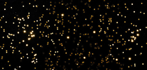 little gold stars on black background Festive holiday background. Celebration concept. Top view,