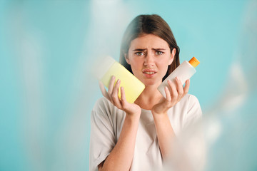 Young sad woman holding plastic waste disappointedly looking in camera over colorful background isolated