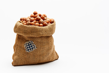 Bag with hazelnuts on a white background. Copy space.