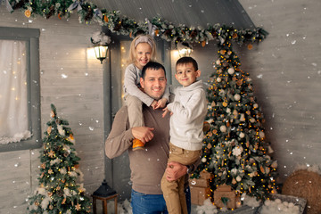 portrait of a happy family on the winter veranda, waiting for the new year and merry christmas