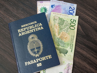 Argentine passport and peso bills, Argentine currency. Travel preparations.