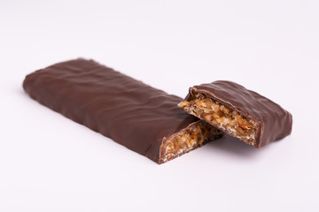 Chocolate bar close-up. Broken chocolate bar with a filling on a white background.