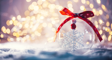 Christmas glass ball with a snowflake inside on snow