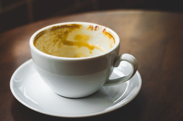 close up modern hot black coffee the espresso on dark background with coffee bubble foam pattern and texture in empty white cup looking and feel so delicious on glasses table in coffee shop.