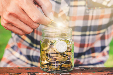 businessman putting coin stacking in to glass jar count the money for saving concept. budgeting for investment startup business.