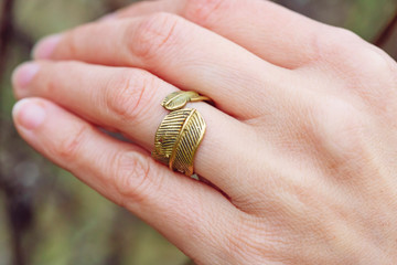 Woman wearing brass ring in the shape of leaf