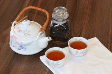 Green tea cups and glass jars with dry green tea