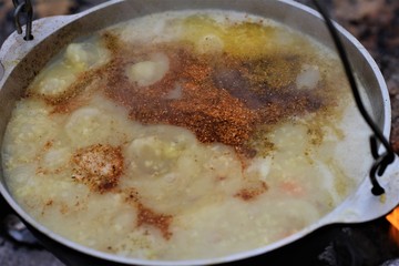 soup in a cauldron on a fire with spices