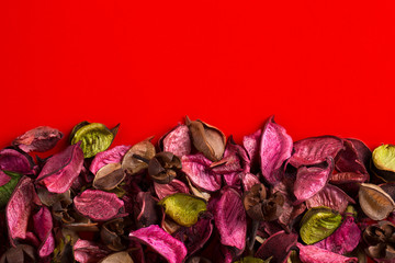 Dry potpourri leaves close-up. Potpourri on a red background. Flavored potpourri leaves.