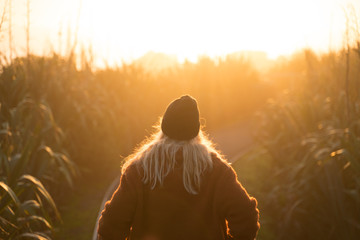 Junge Frau läuft in den Sonnenuntergang.