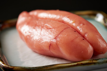 Polloc roe on plate on black background 