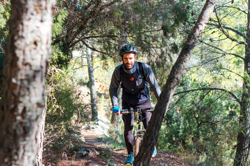Fototapeta premium Chico joven realizando ciclismo en la montaña durante un día de invierno
