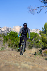 Chico joven realizando ciclismo en la montaña durante un día de invierno