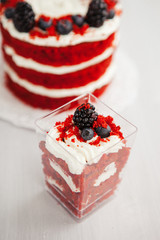  homemade portioned dessert red velvet decorated with berries on a light wooden background