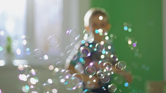 Soap bubbles background. Boy playing with soap bubbles