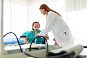 Obraz premium Asian beautiful woman doctor smiles and makes eye contact with the old lady patient. The old lady entered the car. Encouraging the sick