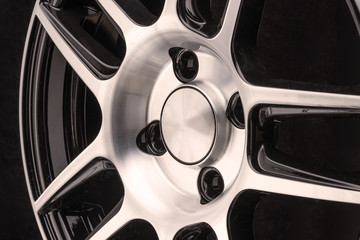 car cast aluminum alloy wheels, black silver with polished front, very beautiful and modern, fashion. Close-up on dark background, elements, spokes.