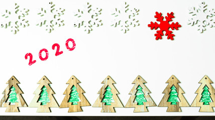 New Year 2020 and Christmas decoration: white and red snowflakes and chritmas trees on the white background. Flat lay, top view, copy space