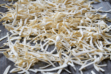 Handmade noodles are dried on a wooden board