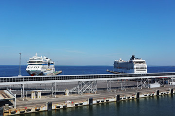 Big white ship ferry vacation trip in Tallinn port dock harbor on water. Blue sky and bright day in...