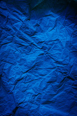 Rough navy blue paper texture. Blue crumpled paper texture and background. Close up view of wrinkled navy blue texture.