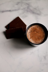cocoa drink in a blue mug with chocolate on a light background closeup