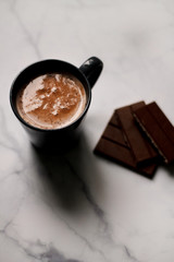 cocoa drink in a blue mug with chocolate on a light background closeup
