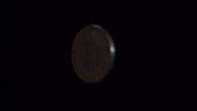 A large cryptocurrency of bitcoins slowly appears and disappears in black space, symbolizing a deceiving illusory profit. Come and go