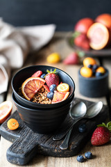 Homemade granola with fresh berries, fruit for Breakfast. The concept of healthy eating. Wooden table. Dark background