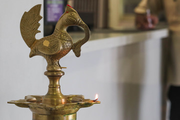Indian Common Brass Diya Lamp Glowing with Blurred Hotel Reception Background