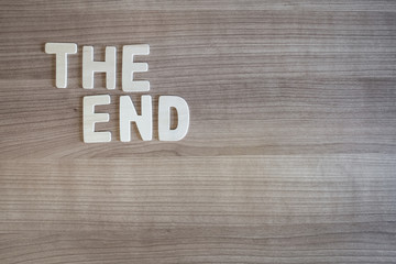 The End words with wood letters over wood background